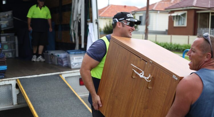 Image of man and van lifting furniture onto the removal truck for transport.